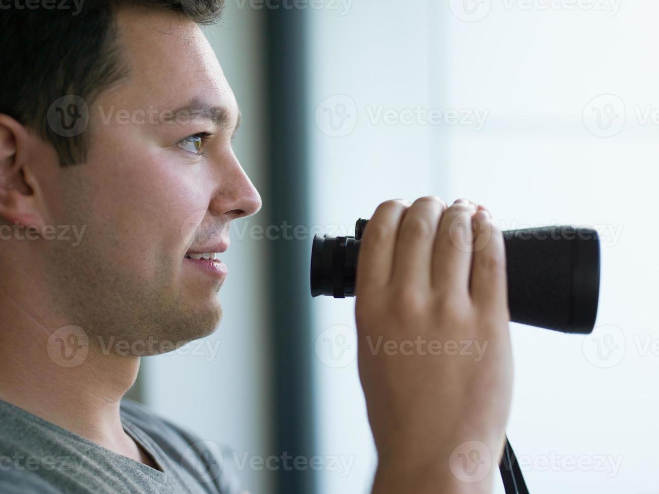 man looking with binoculars photo