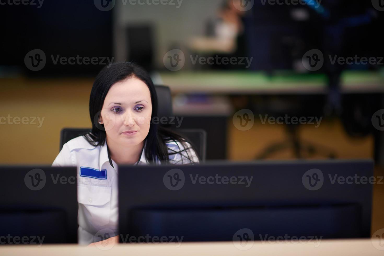 Female operator working in a security data system control room photo