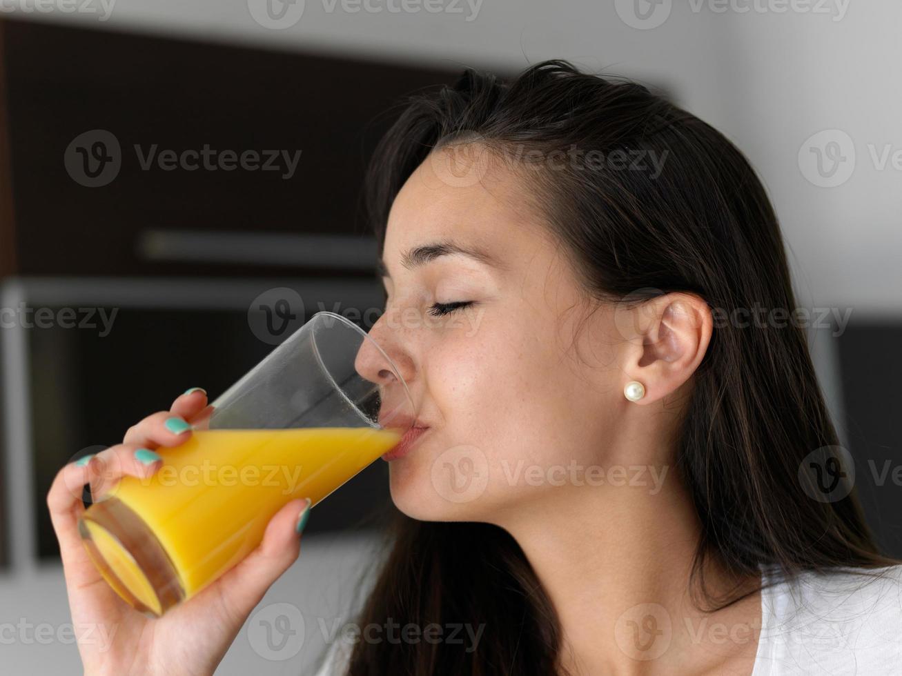 woman drinking juice in her kitchen photo