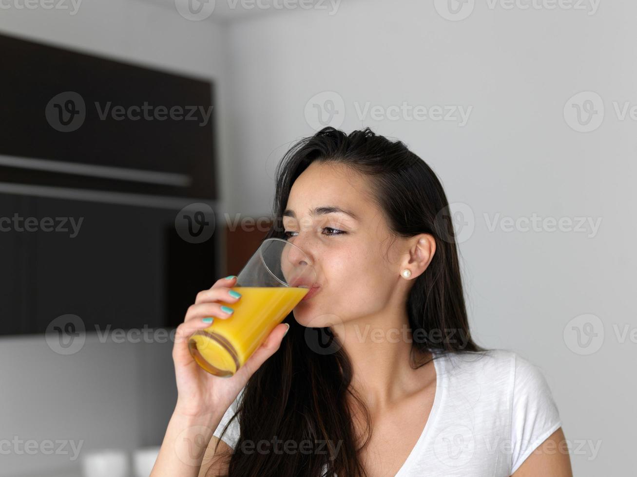 woman drinking juice in her kitchen photo