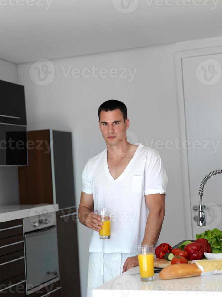 hombre cocinando en casa preparando ensalada en la cocina foto