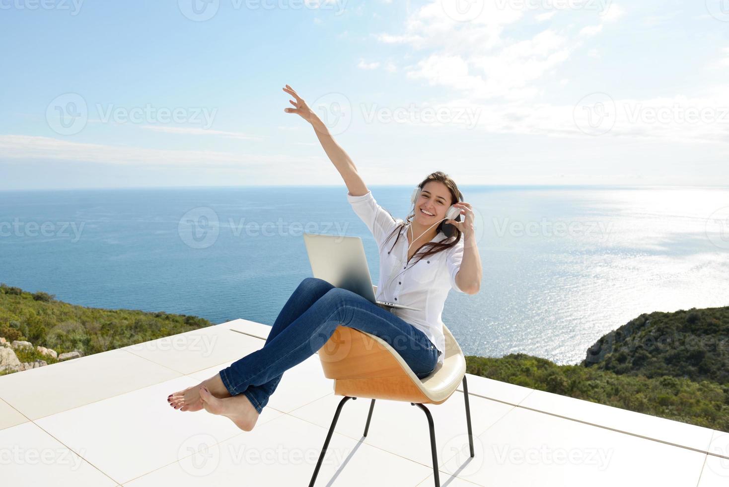 relaxed young woman at home working on laptop photo