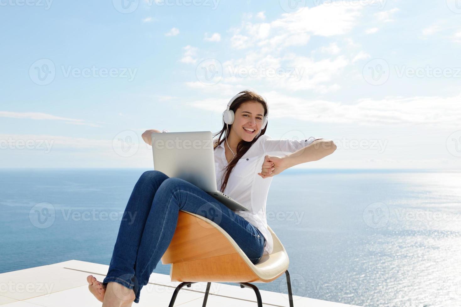 relaxed young woman at home working on laptop photo