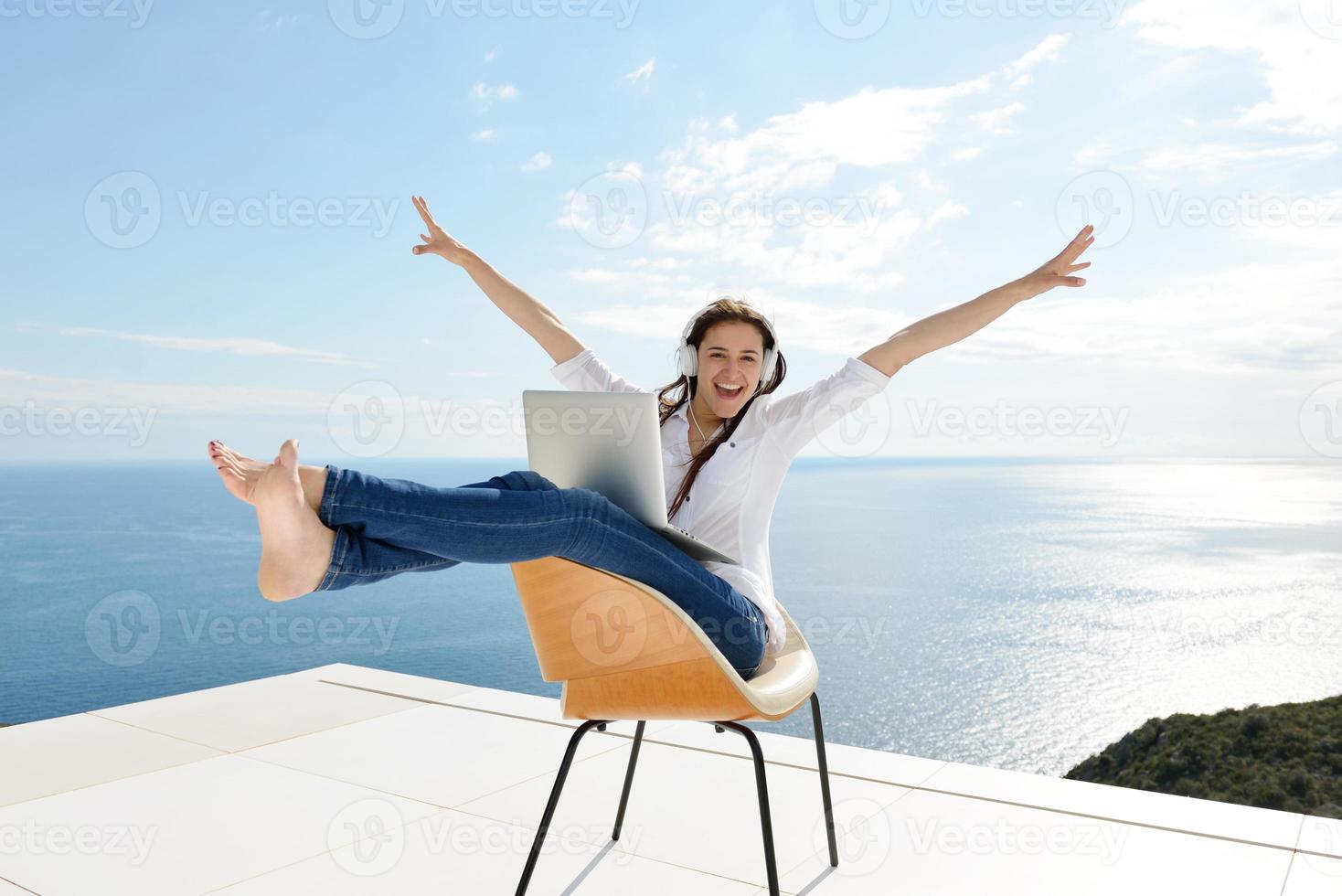 relaxed young woman at home working on laptop photo