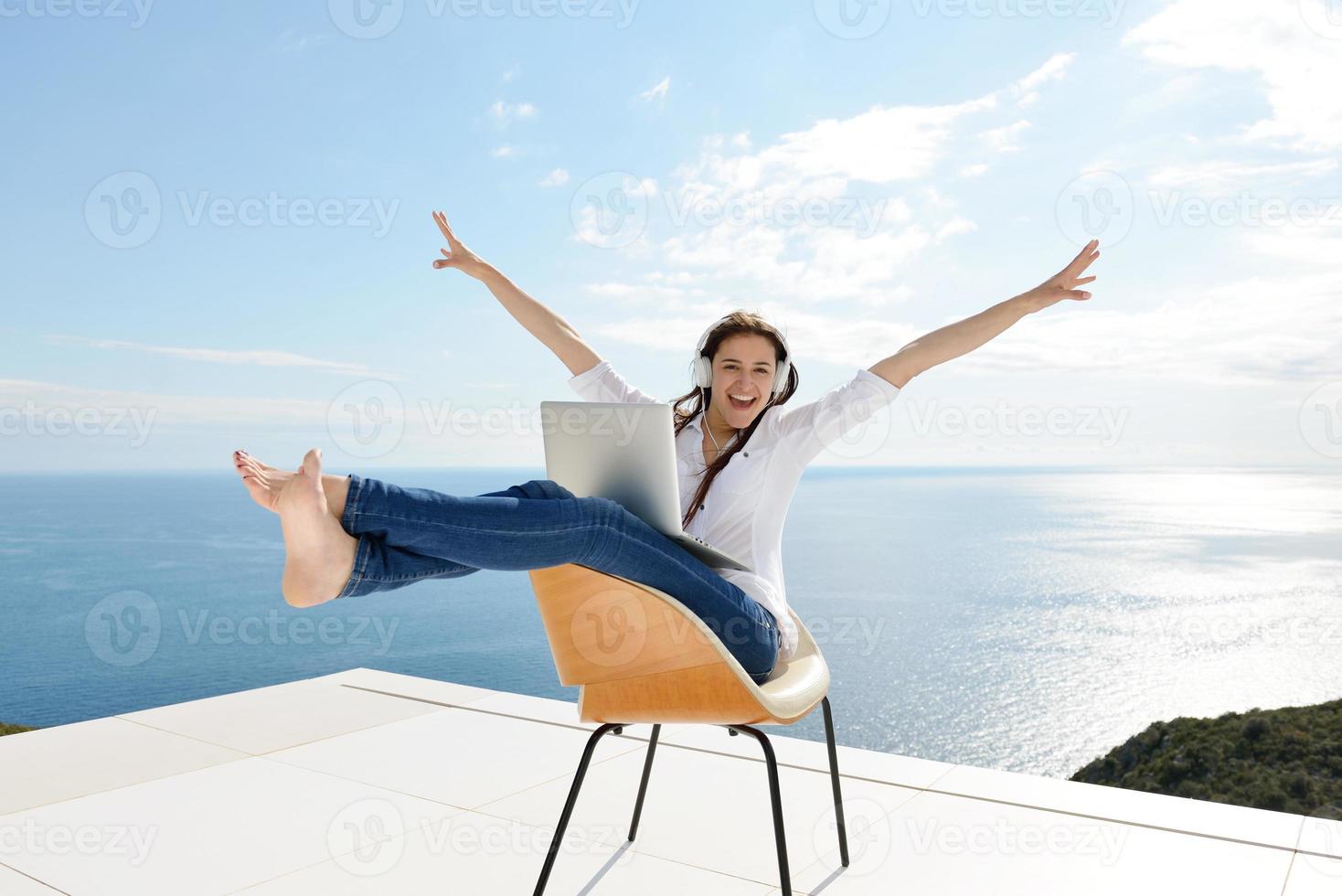 relaxed young woman at home working on laptop photo