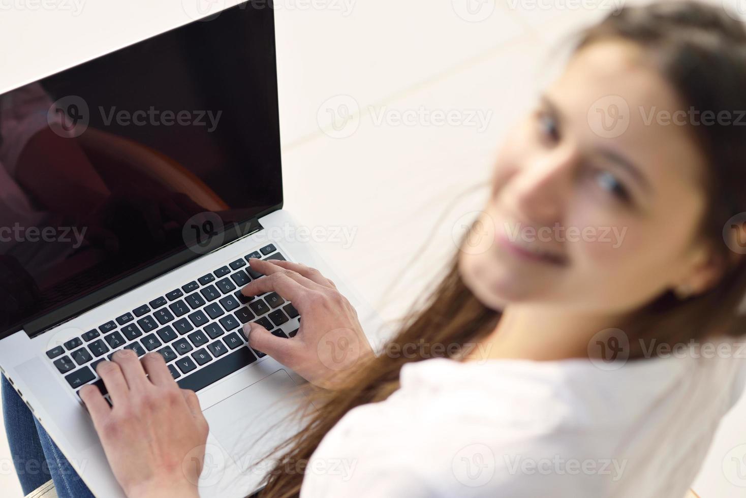 mujer joven relajada en casa trabajando en una computadora portátil foto