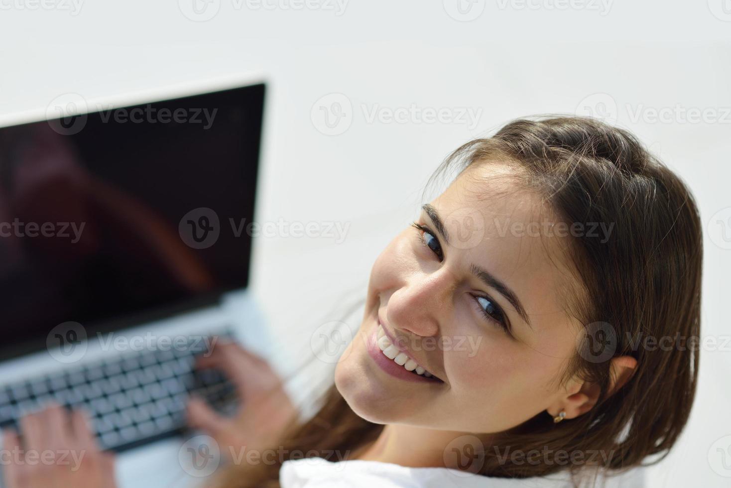 mujer joven relajada en casa trabajando en una computadora portátil foto