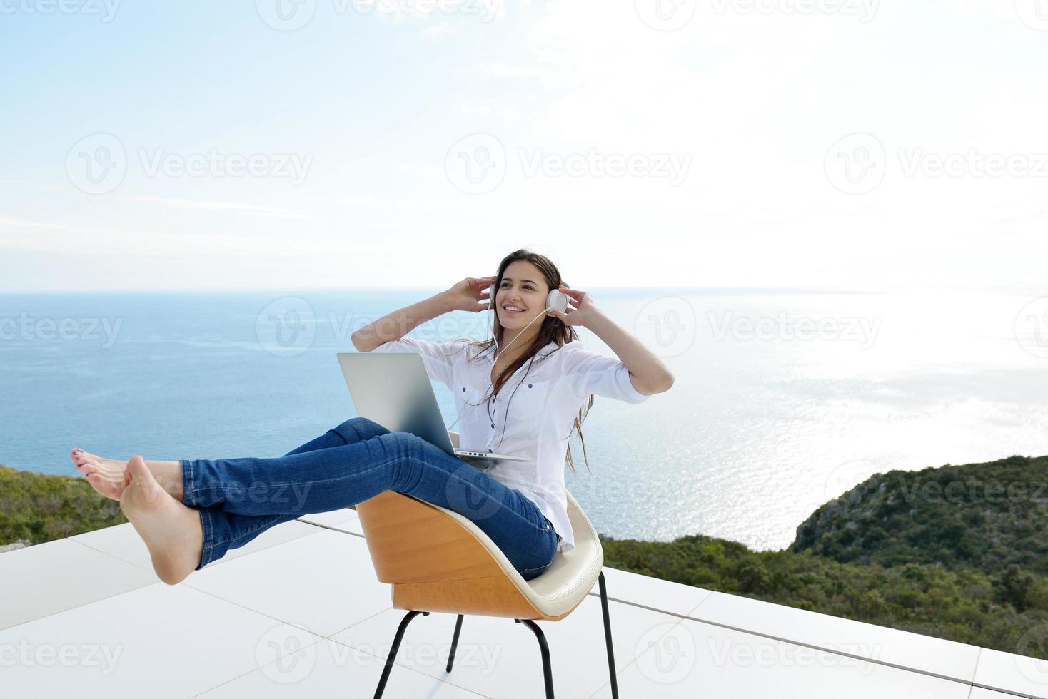 relaxed young woman at home working on laptop photo