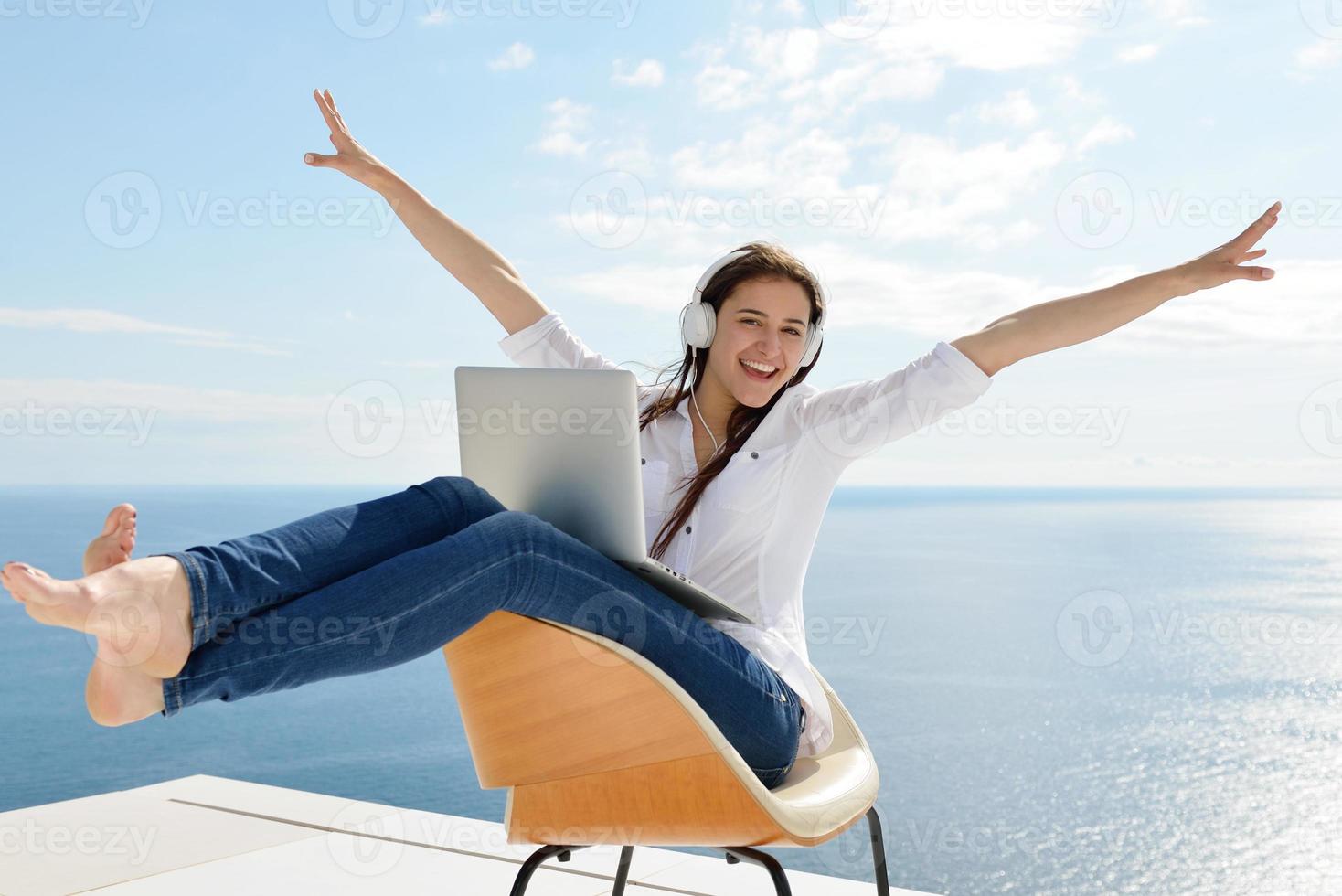 relaxed young woman at home working on laptop photo