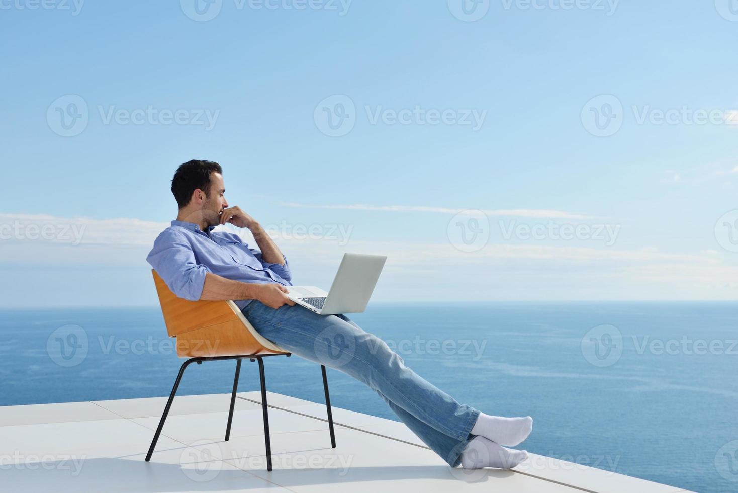 relaxed young man at home on balcony photo
