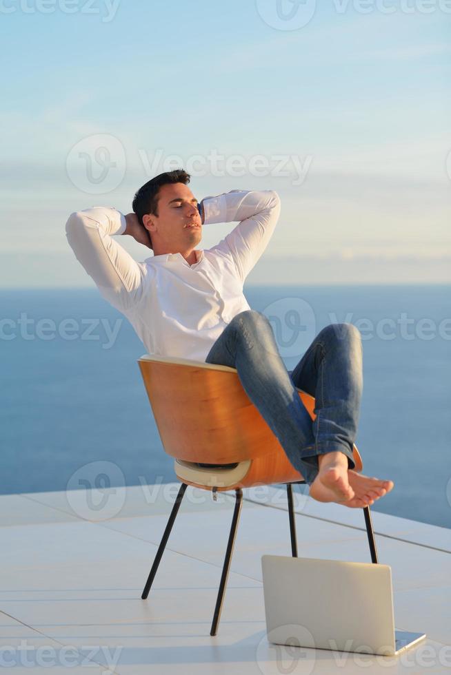 relaxed young man at home on balcony photo