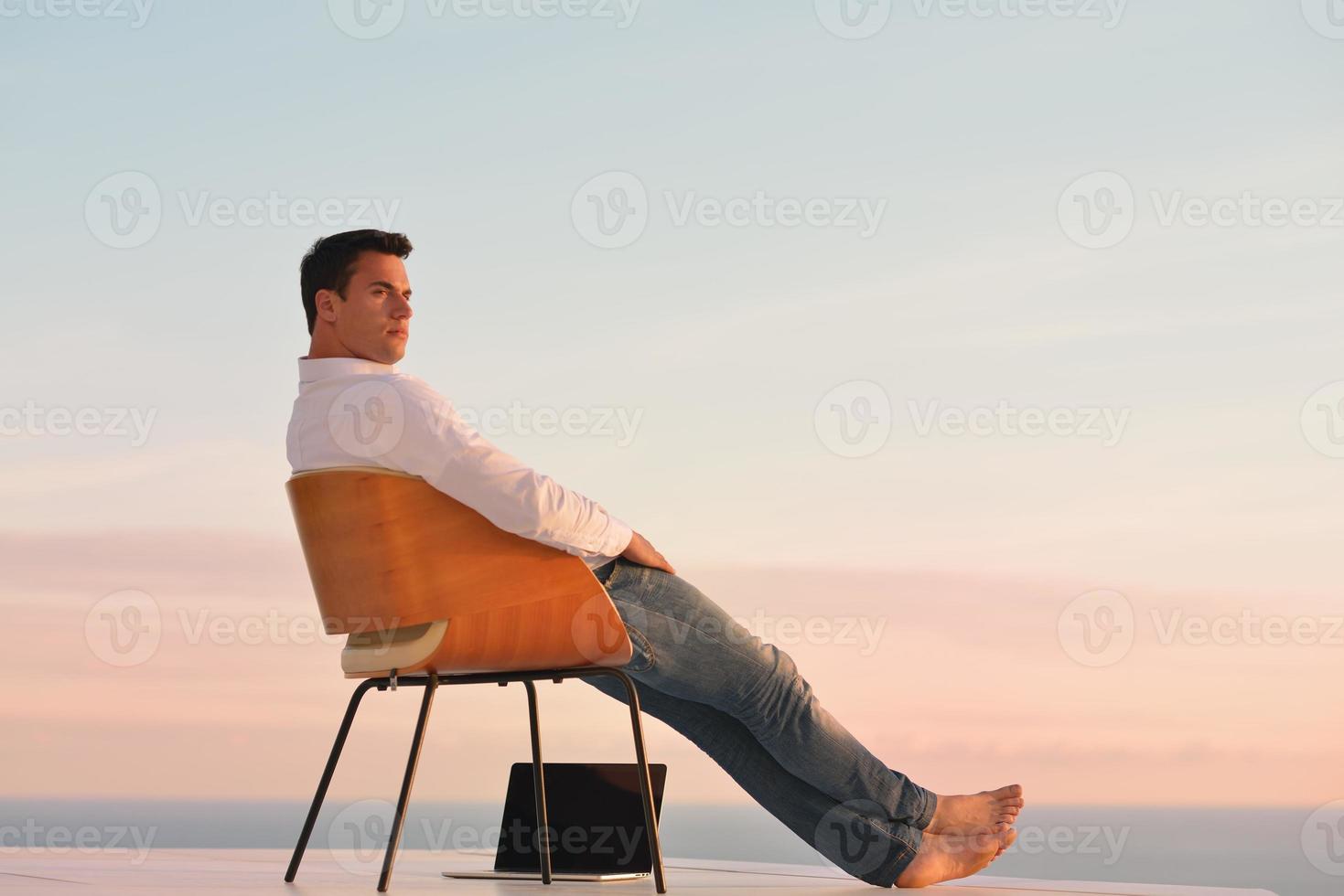 relaxed young man at home on balcony photo