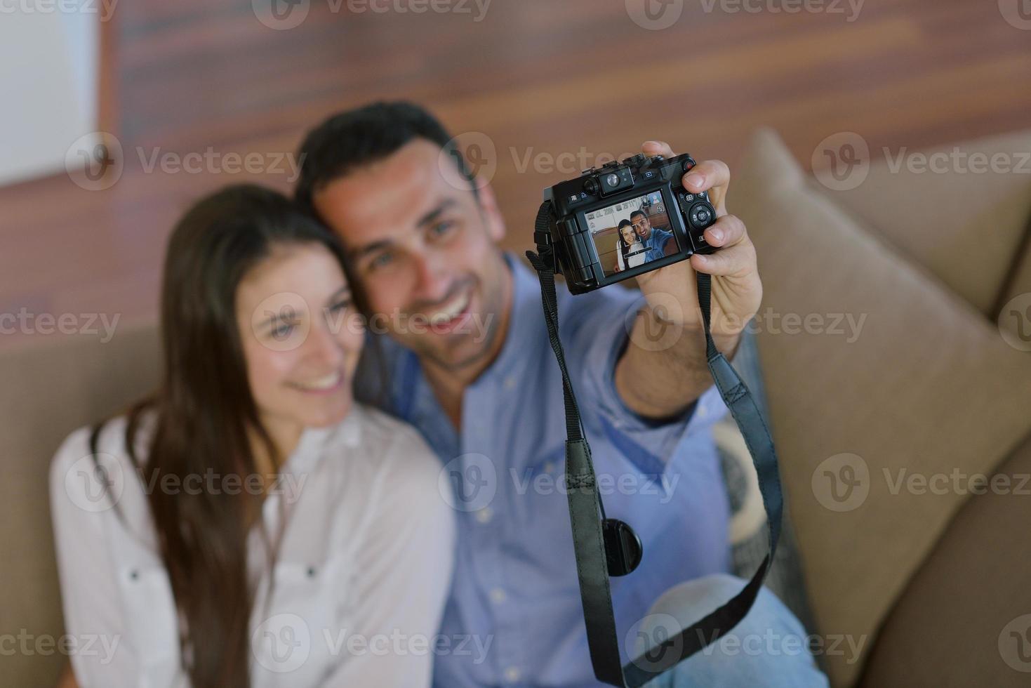 couple playing with digital camera at home photo