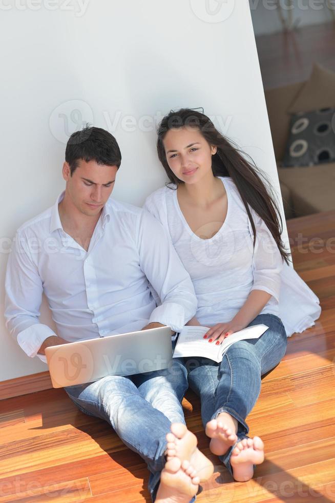 young couple using laptop at home photo