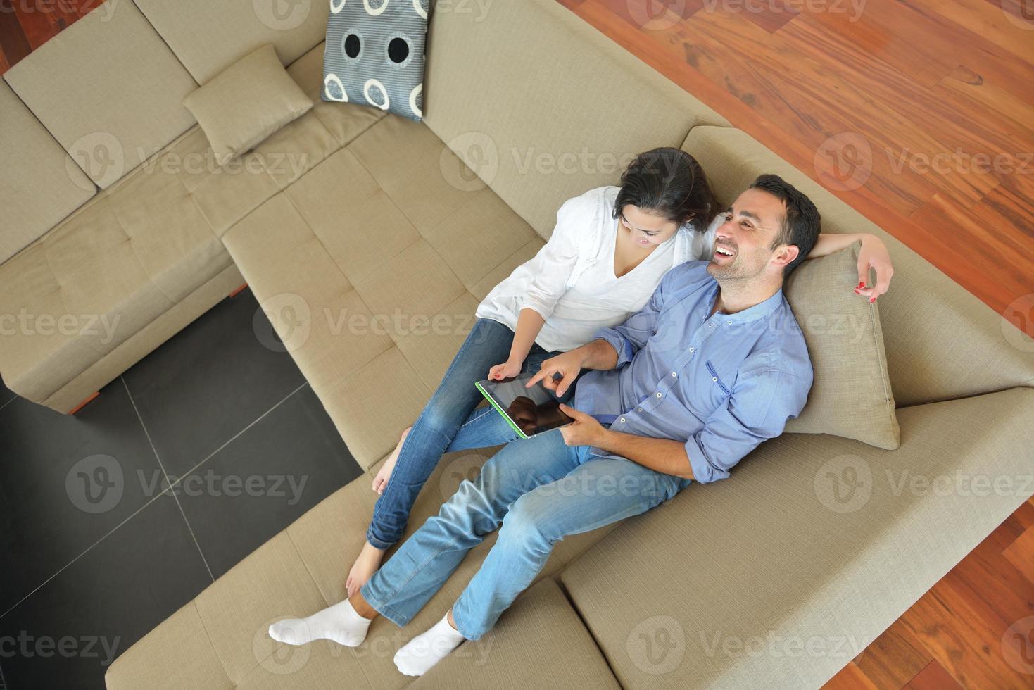 couple at home using tablet computer photo