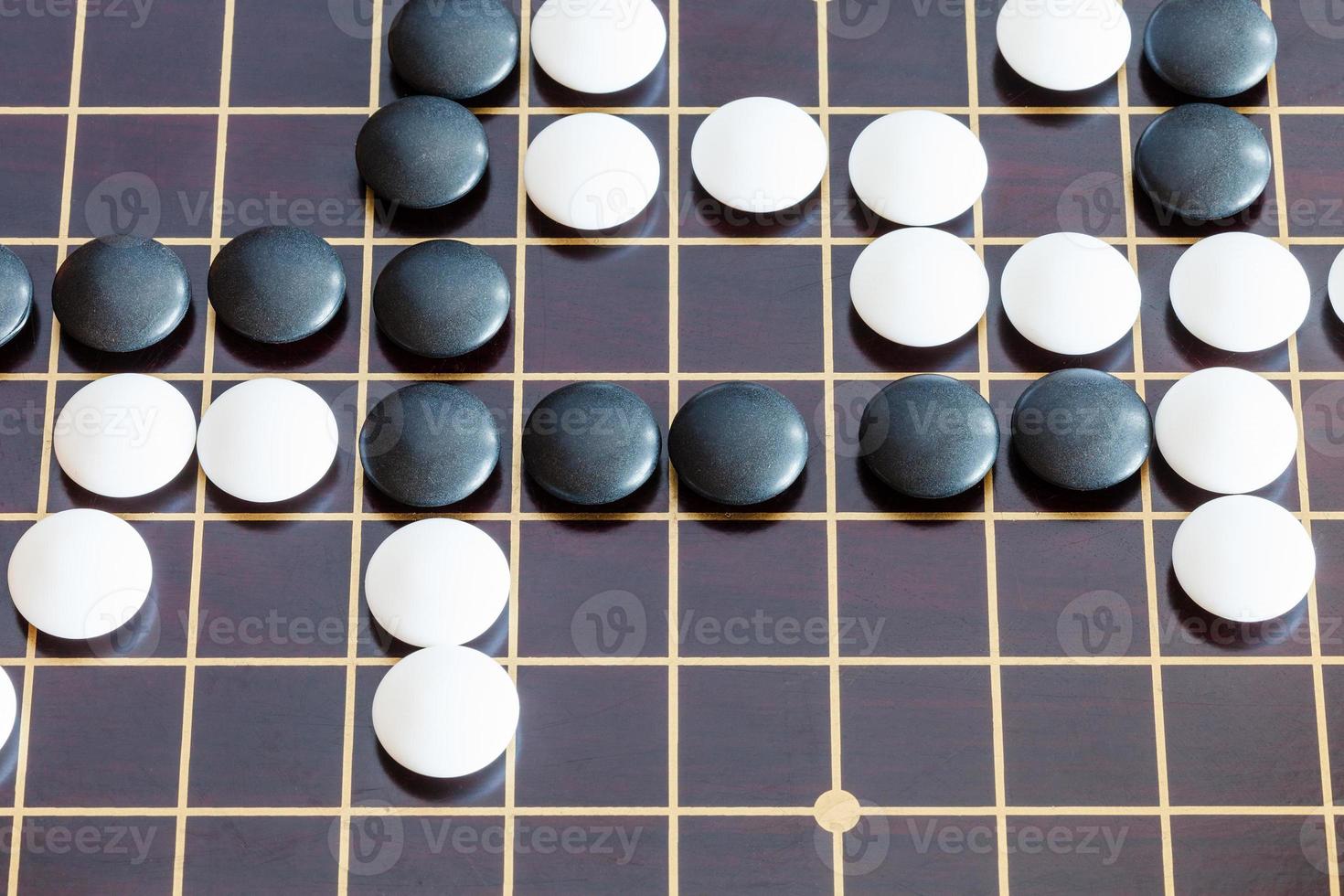 playing in Go game on wooden board photo