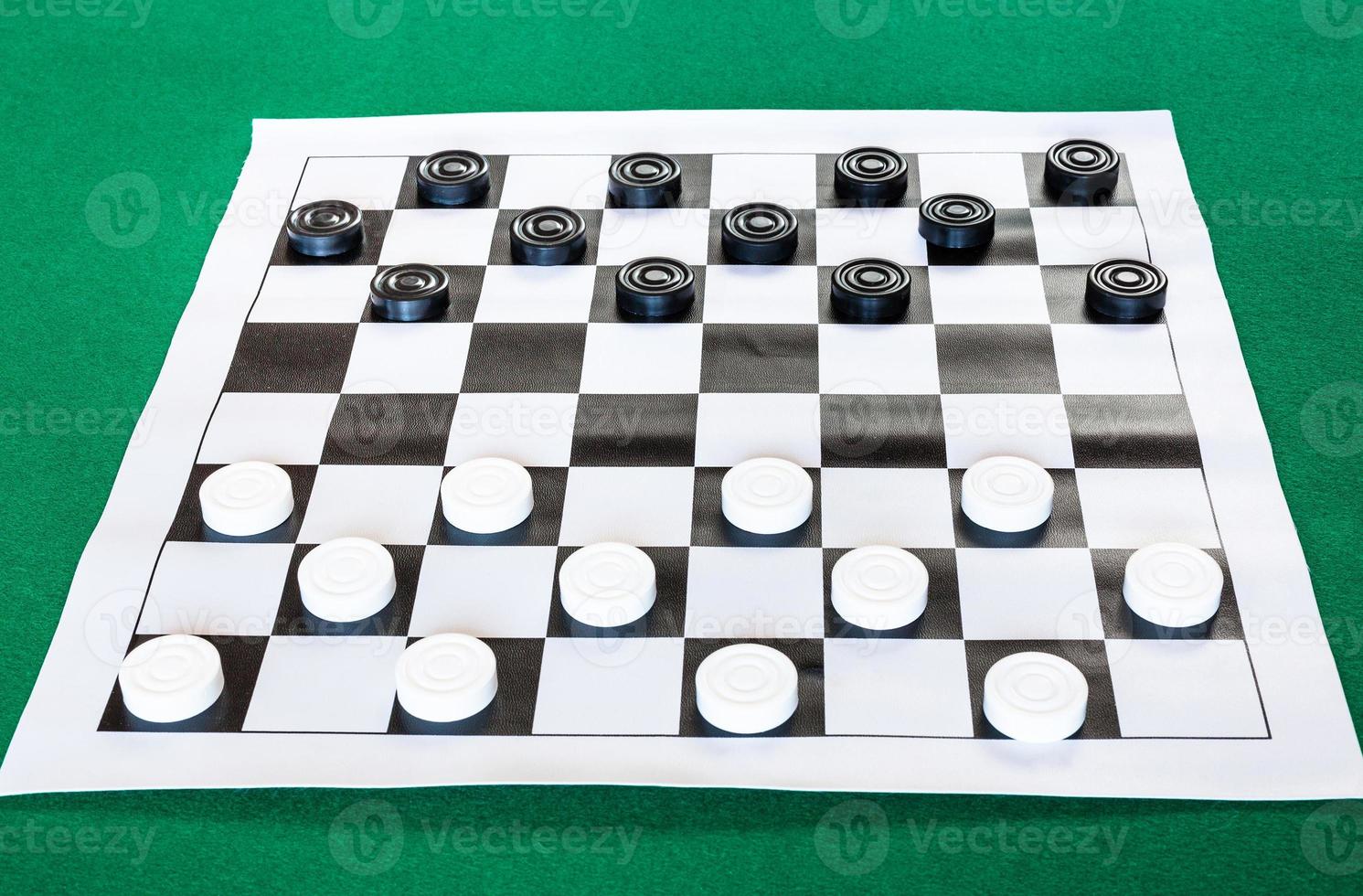 draughts on black and white checkered sheet board photo