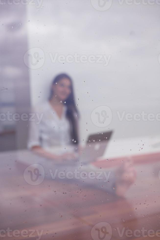 mujer joven relajada en casa trabajando en una computadora portátil foto