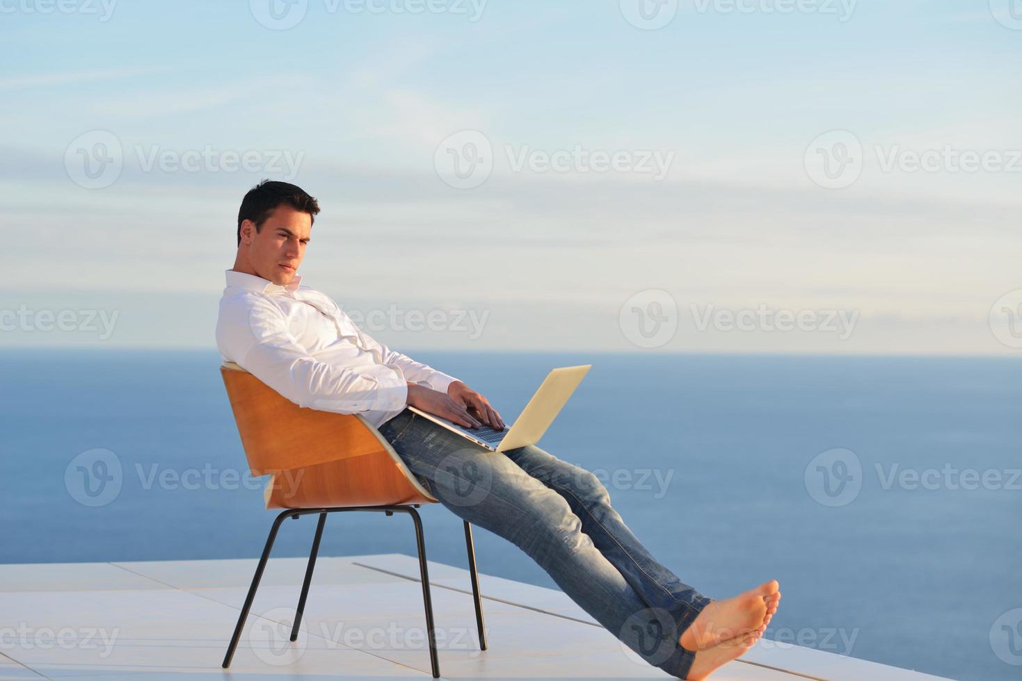 relaxed young man at home on balcony photo