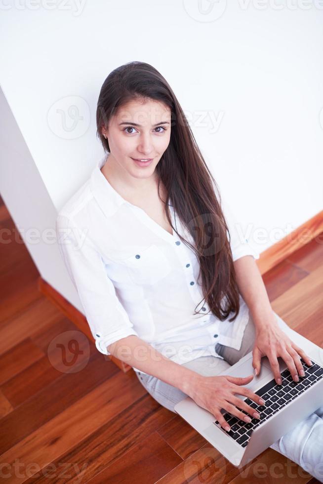 relaxed young woman at home working on laptop computer photo