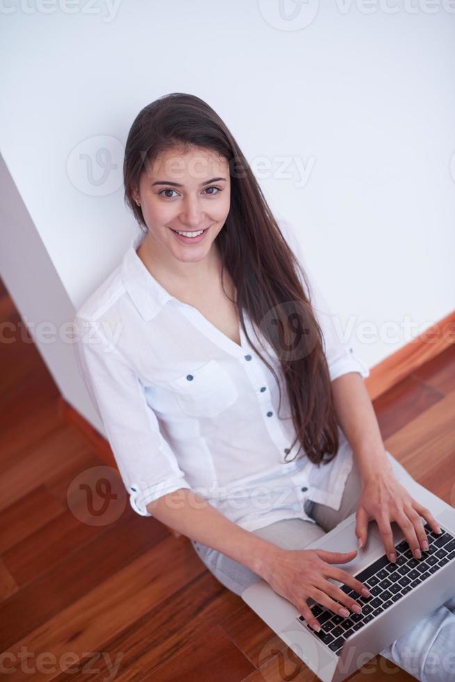 relaxed young woman at home working on laptop computer photo