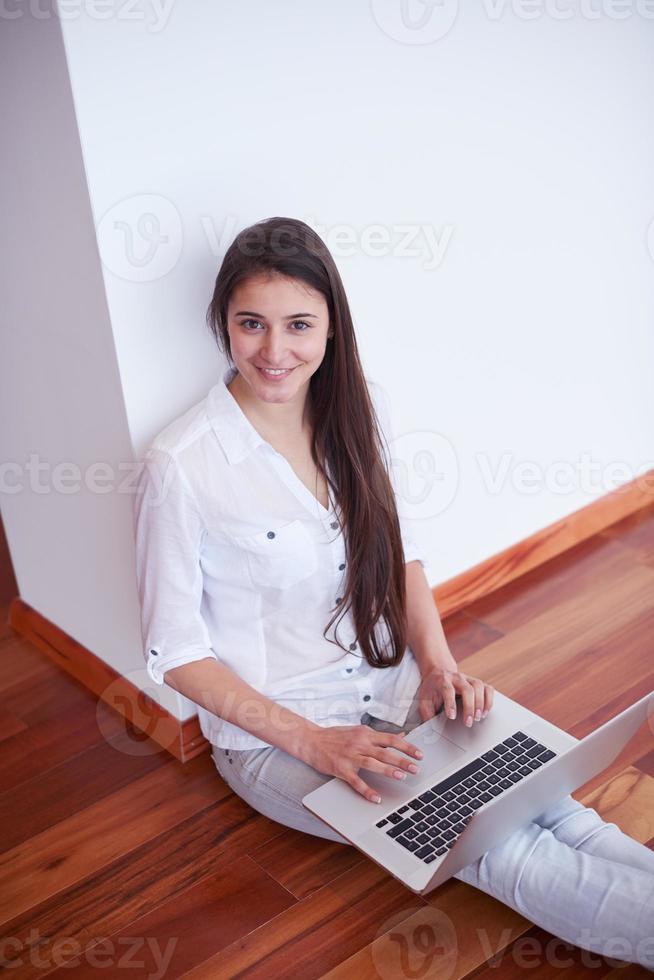 relaxed young woman at home working on laptop computer photo