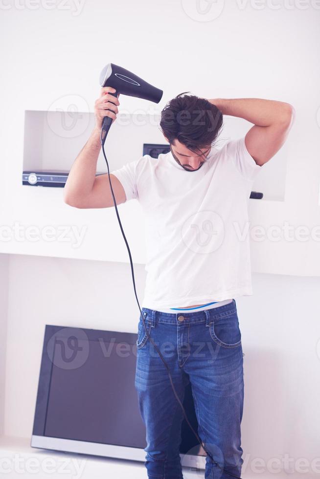 handsome man using  hairdryer photo