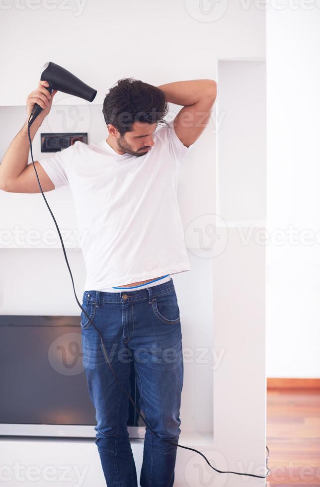 handsome man using  hairdryer photo