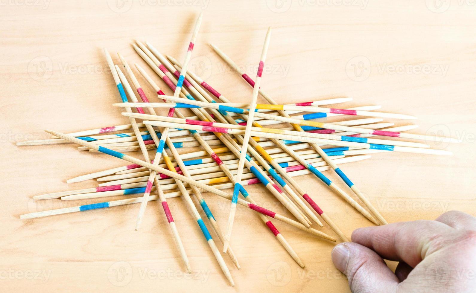 player picks up a stick in Mikado game on board photo