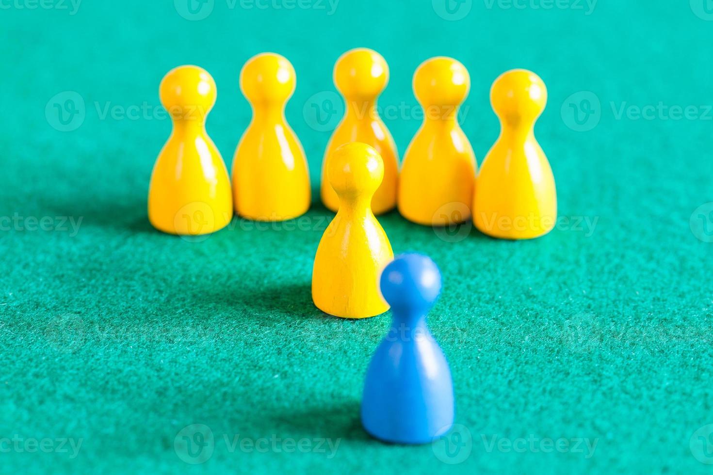 yellow pawns with leader in front of one blue pawn photo