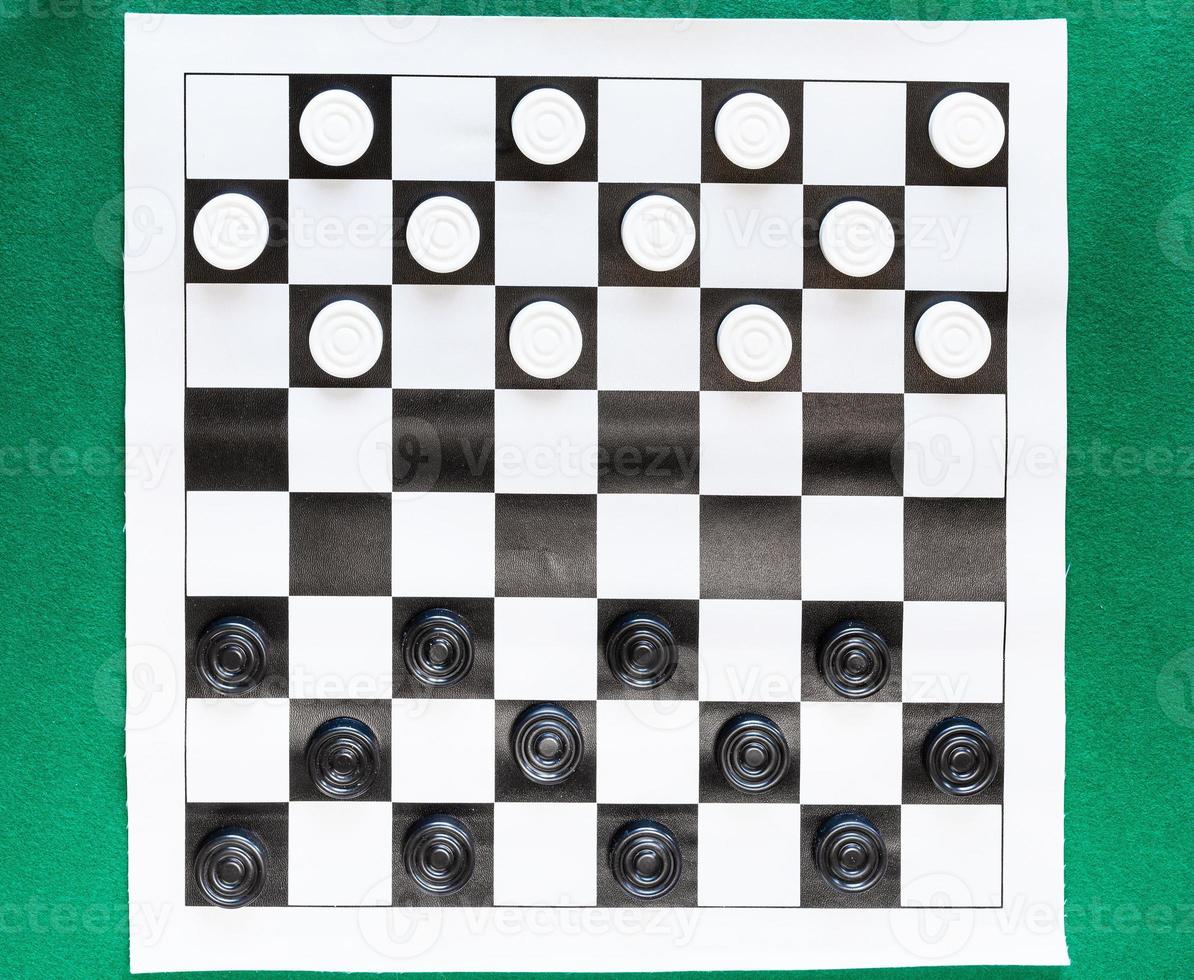 top view of draughts on black and white sheet photo