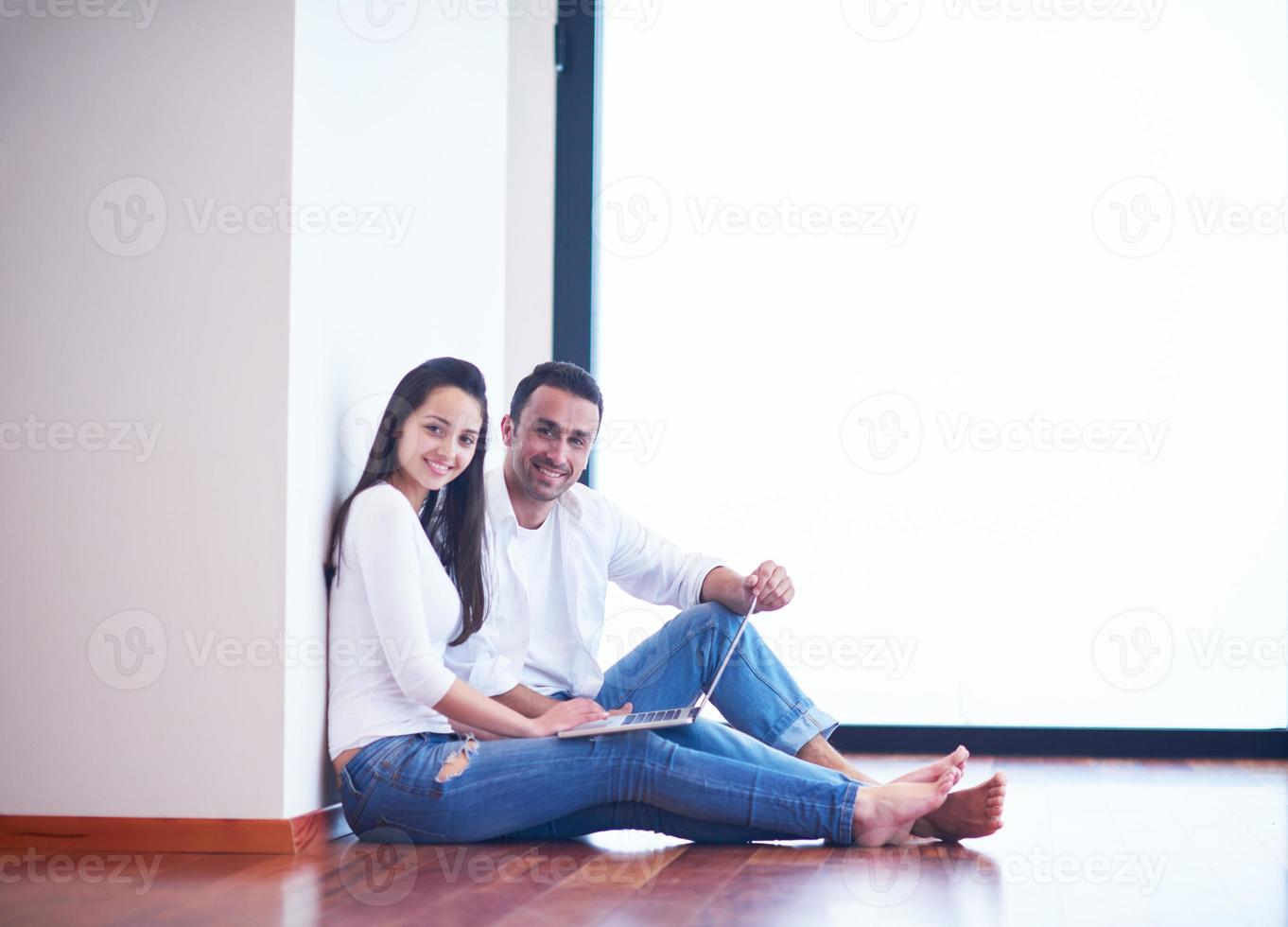 relaxed young couple working on laptop computer at home photo