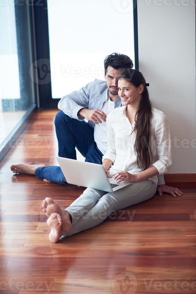 relaxed young couple working on laptop computer at home photo