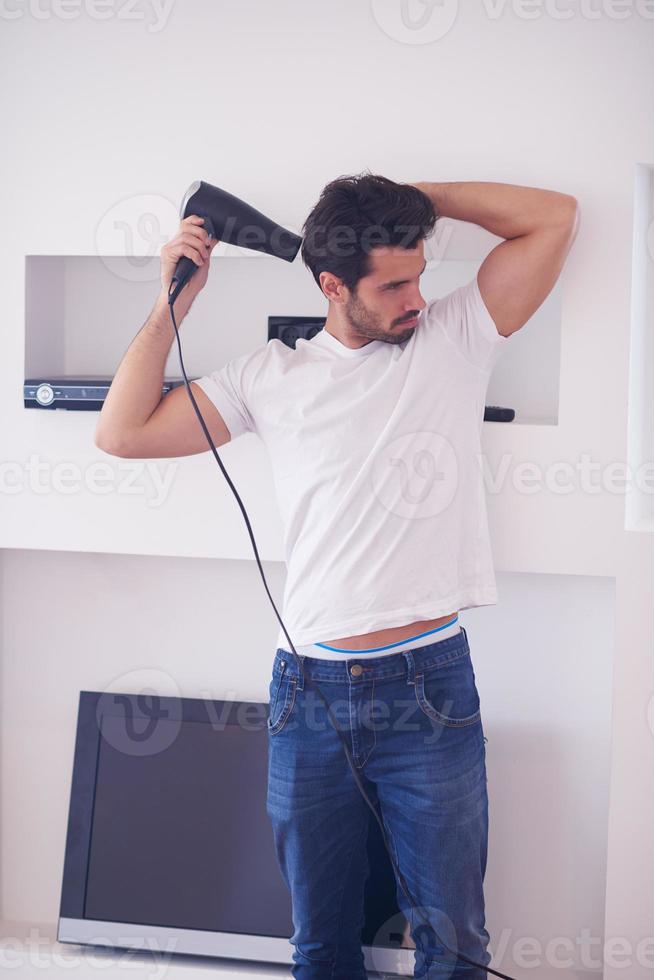 handsome man using  hairdryer photo