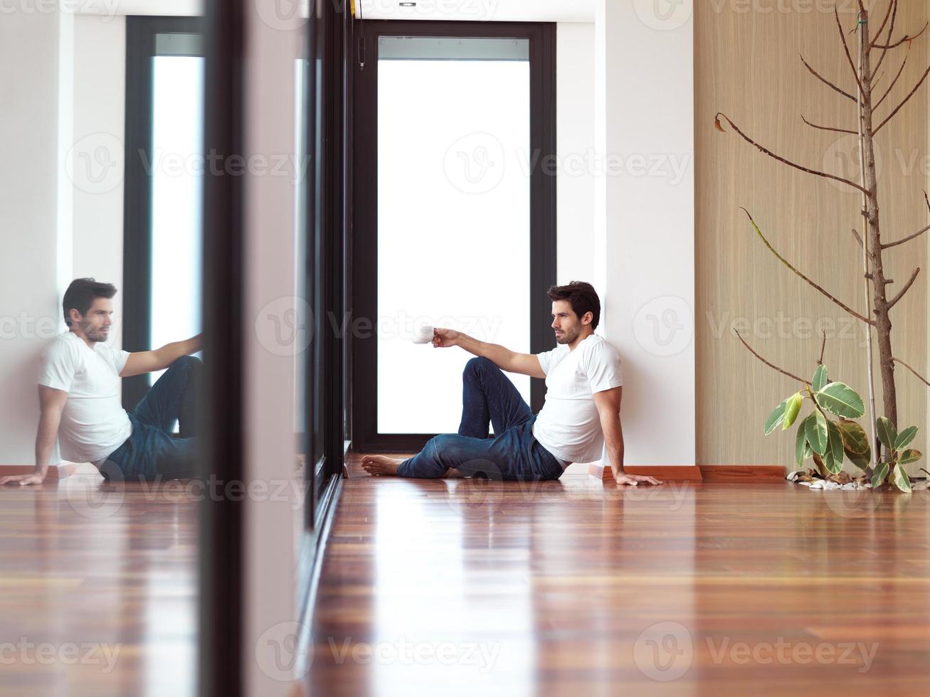 relaxed young man drink first morning coffee photo