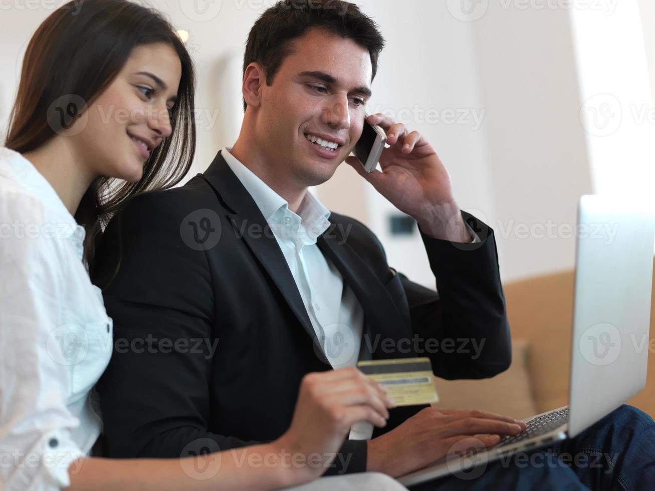 relaxed young couple working on laptop computer at home photo