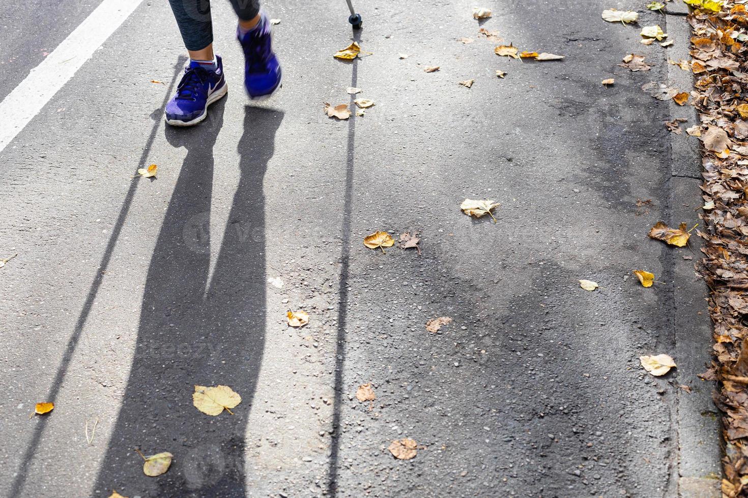 piernas y sombra de caminante de marcha nórdica foto