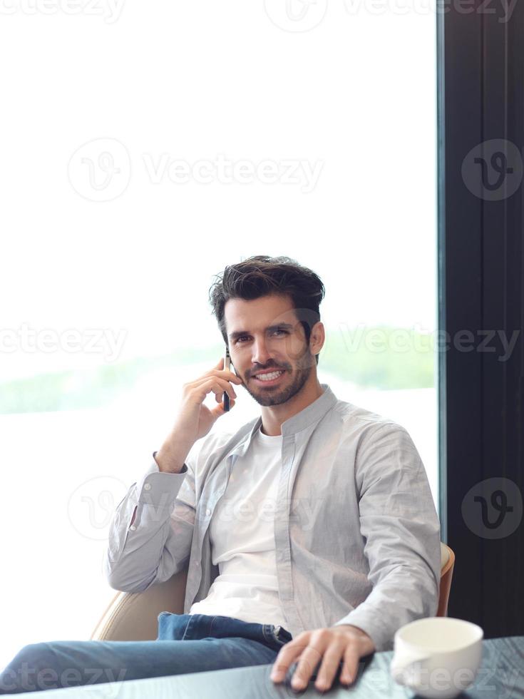 relaxed young man drink first morning coffee photo