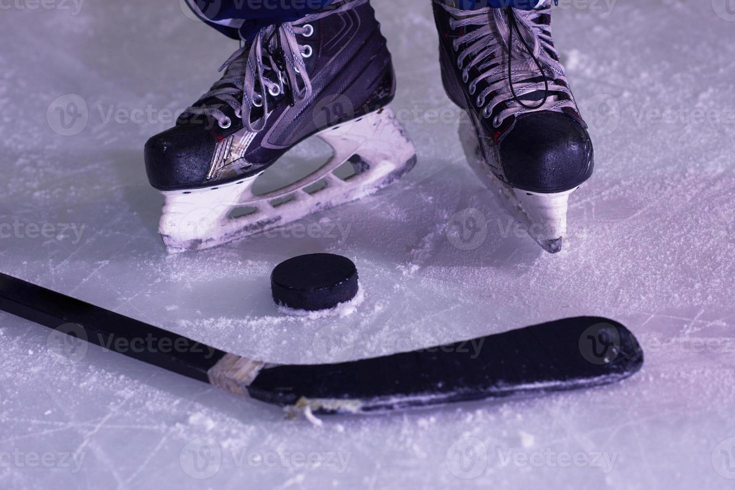 hockey sticsk and puck on ice photo