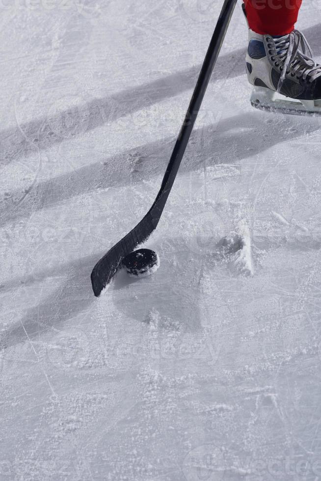 hockey sticsk and puck on ice photo