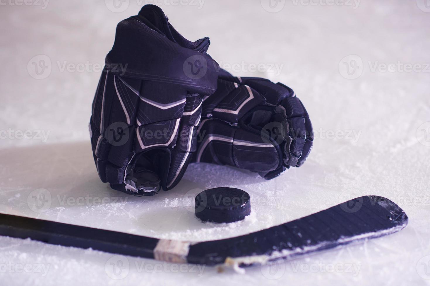 hockey sticsk and puck on ice photo