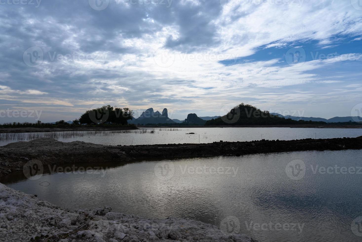 Landscpae of Mountain and Lake with Silhouette of People Working in Field in Lopuri Thailand photo