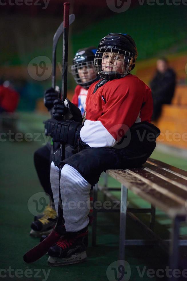 niños jugadores de hockey sobre hielo en un banco foto