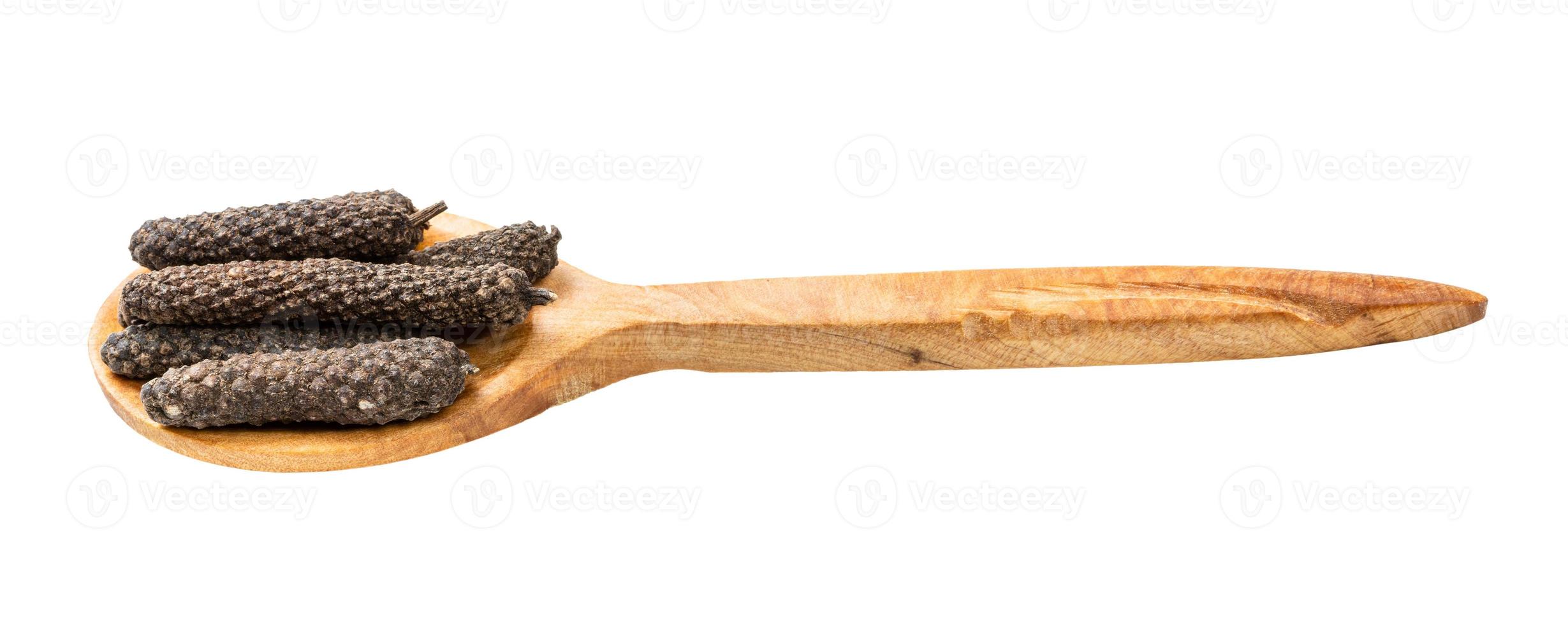 wooden spoon with java long peppers isolated photo