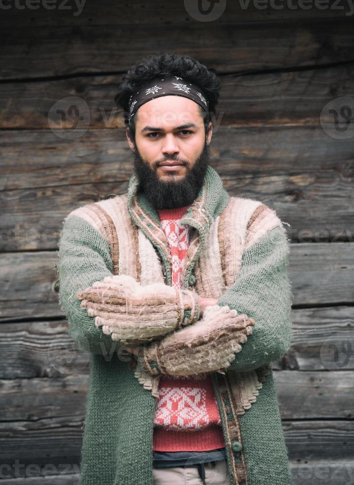 portrait of young hipster in front of wooden house photo