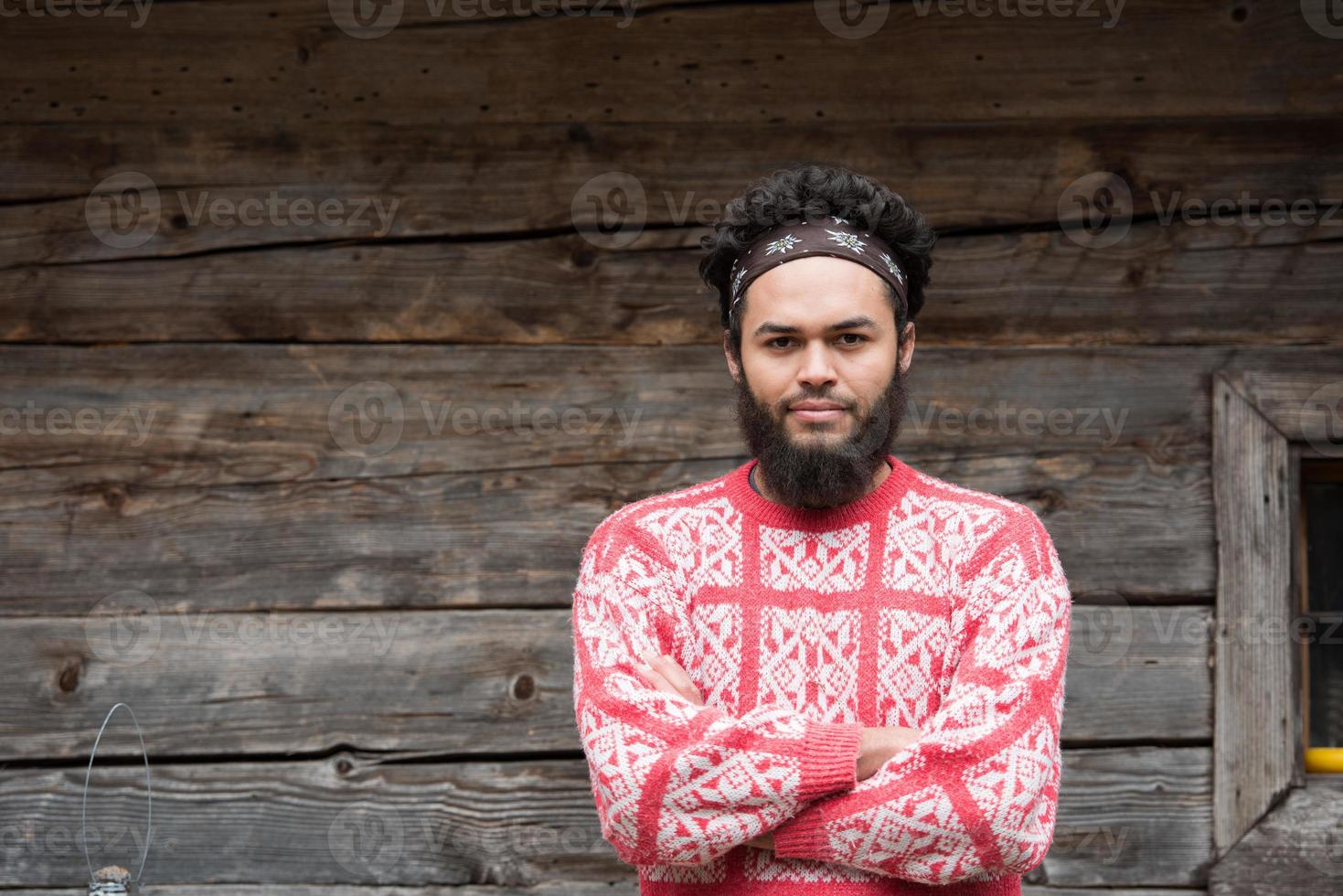 portrait of young hipster in front of wooden house photo