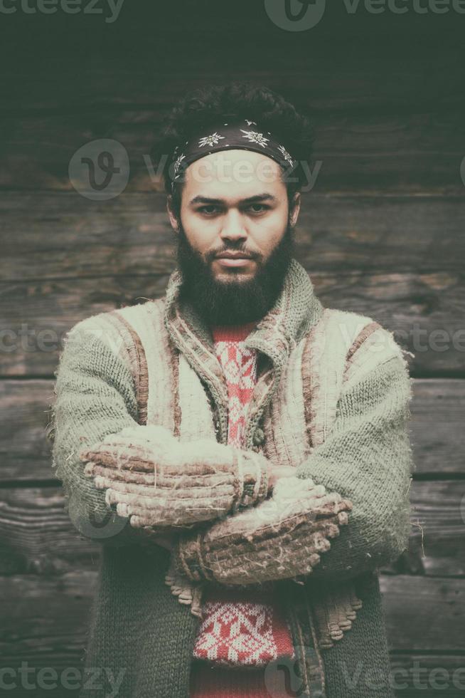 portrait of young hipster in front of wooden house photo