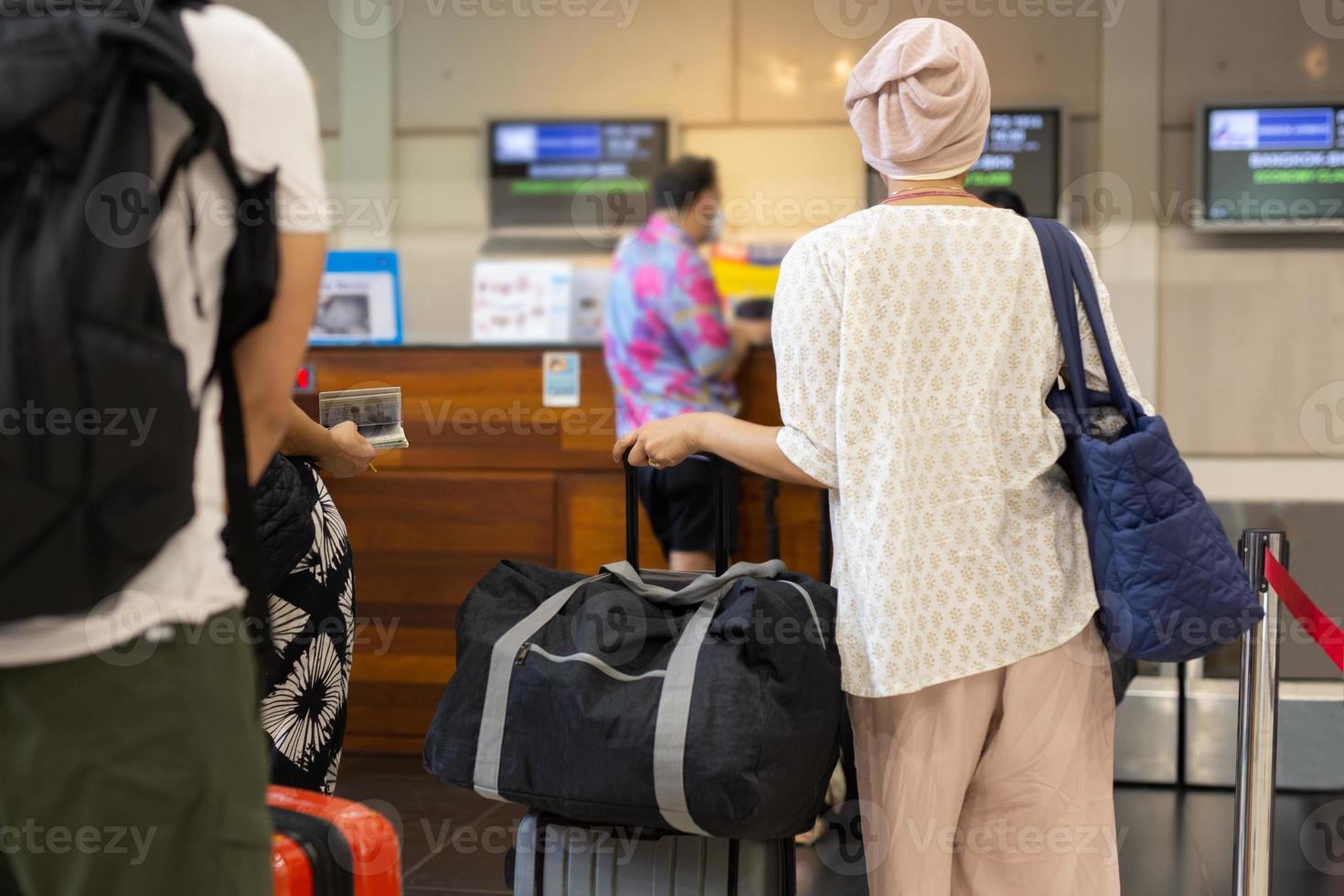 Asian woman tourist standing with luggage at check in counter in airport terminal. photo