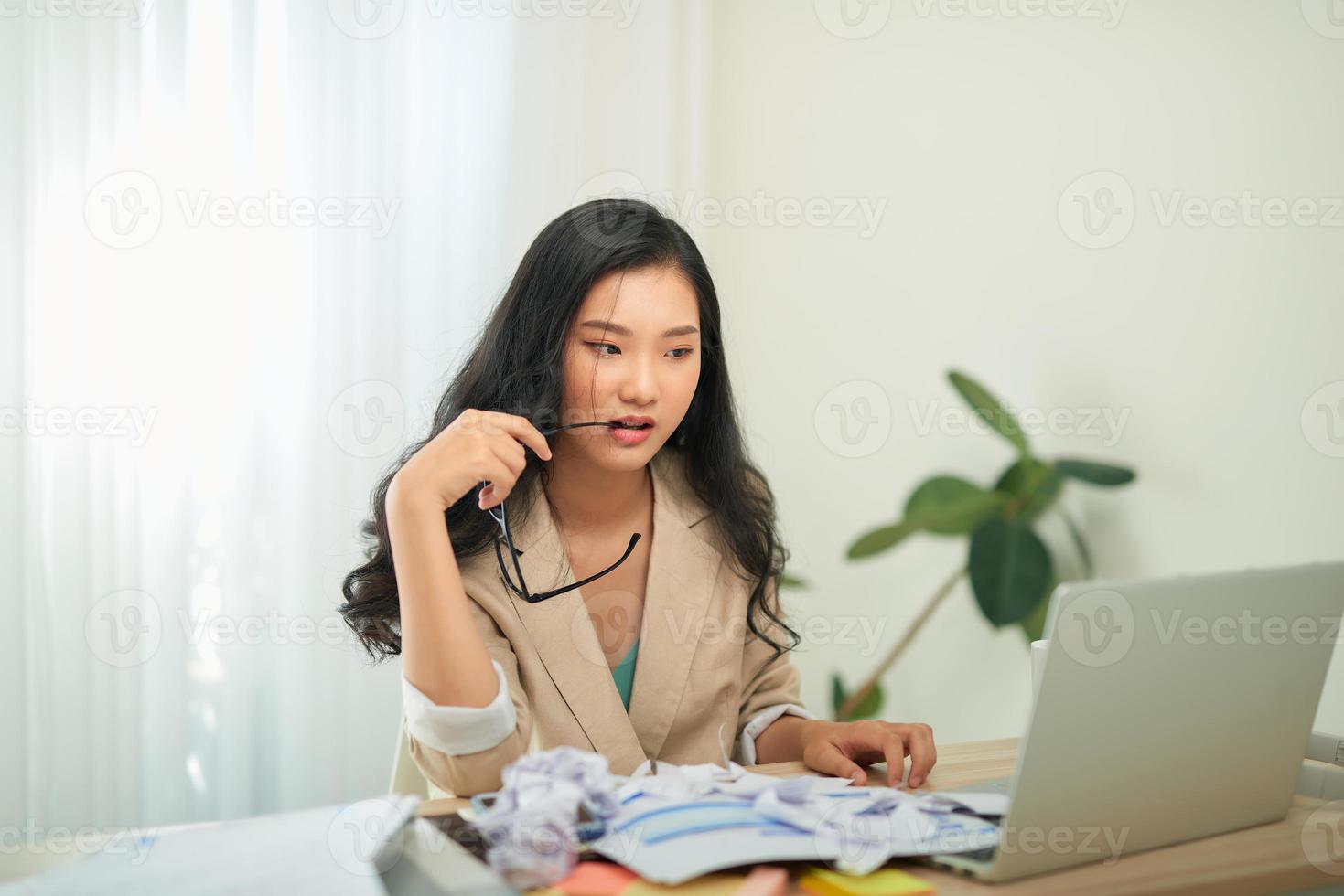 remote job, technology and people concept - stressed young woman with laptop computer and papers working at home office photo