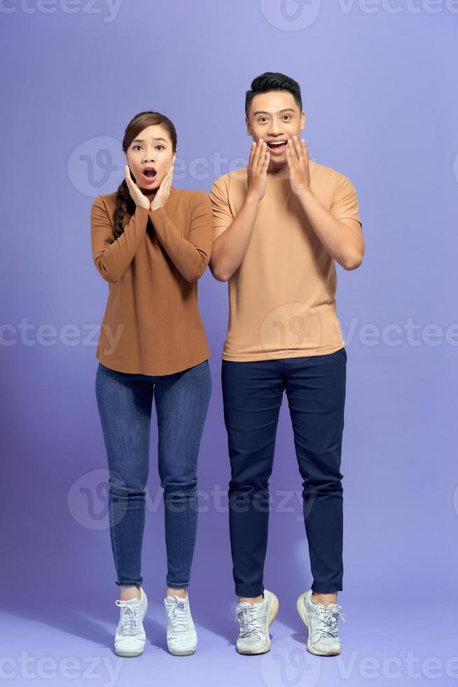 Image of happy friends loving couple standing isolated over purple background screaming looking camera. photo